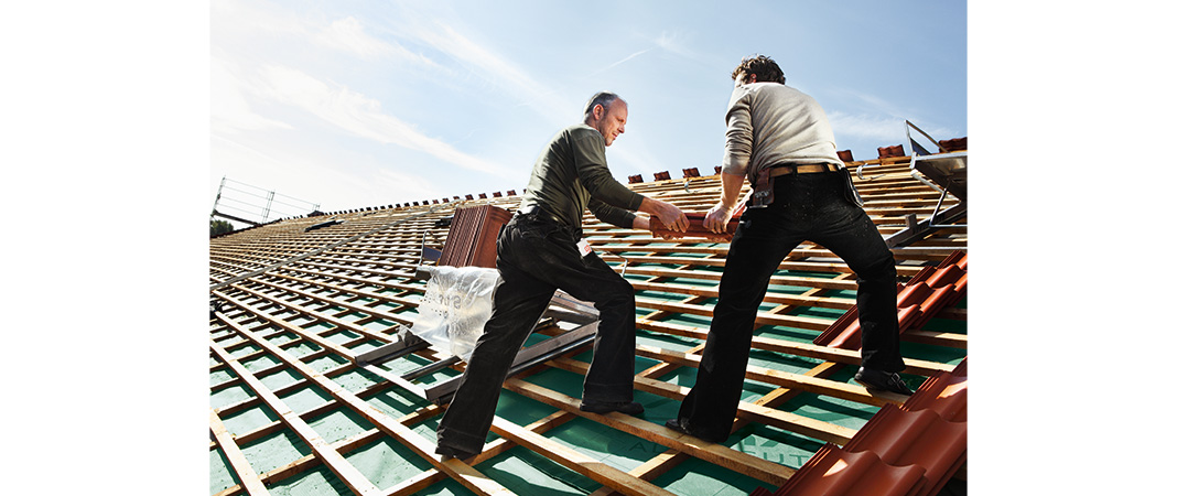 Bild vo dachdeckern beim Verlegen von Dachsteinen