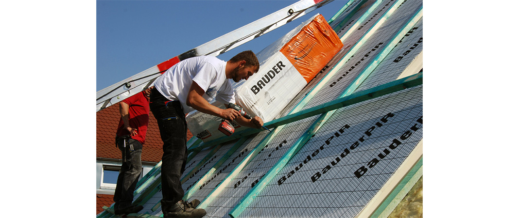 Bild von Dachdeckern bei der Verlegung einer Aufsparrendämmung