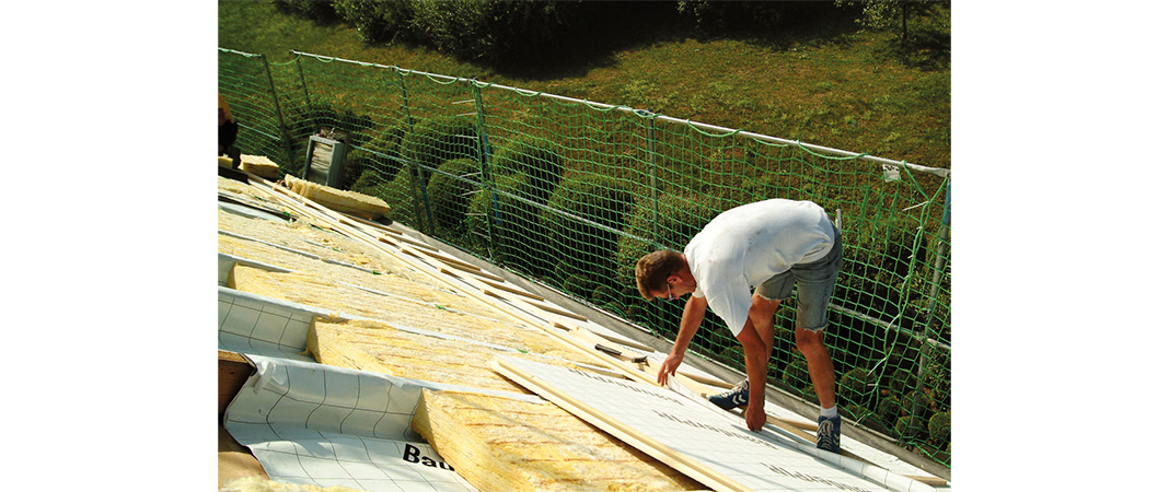 Bild von Dachdeckern bei der Verlegung einer Aufsparrendämmung