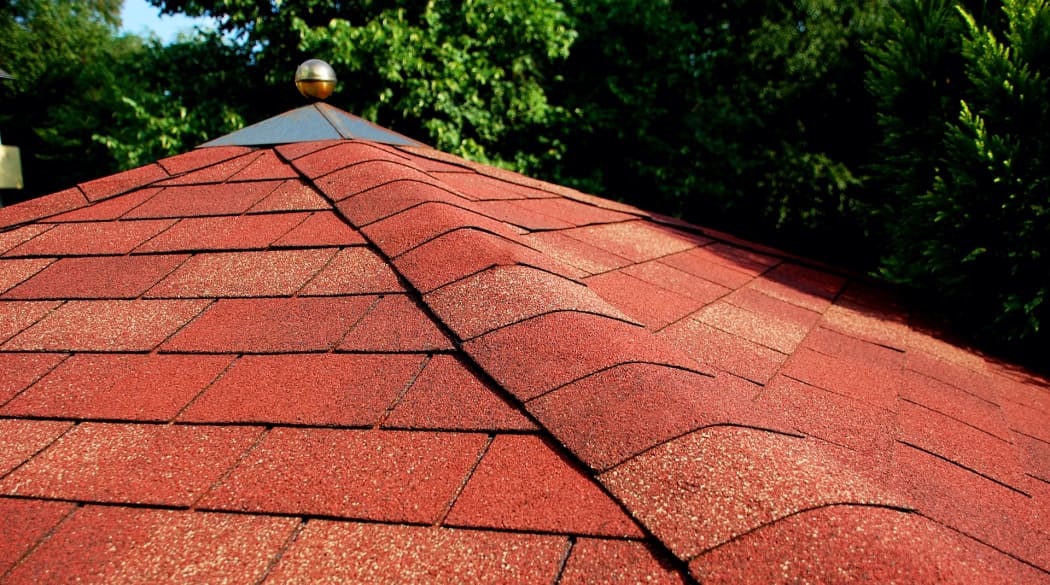 Gartenhaus-Dach mit roten, rechteckigen Bitumenschindeln