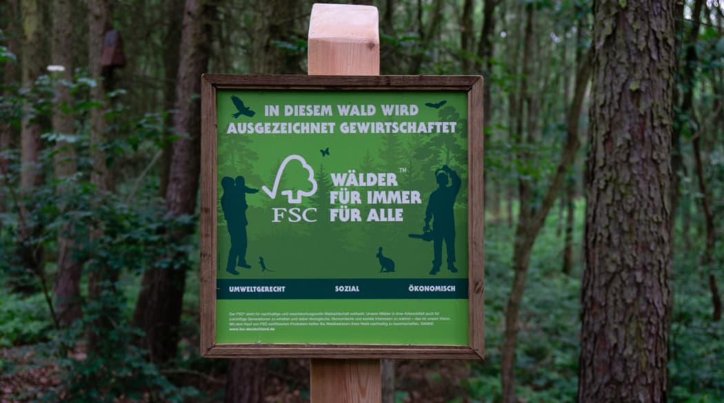 Schild mit dem Gütesiegel FSC vor einem Wald