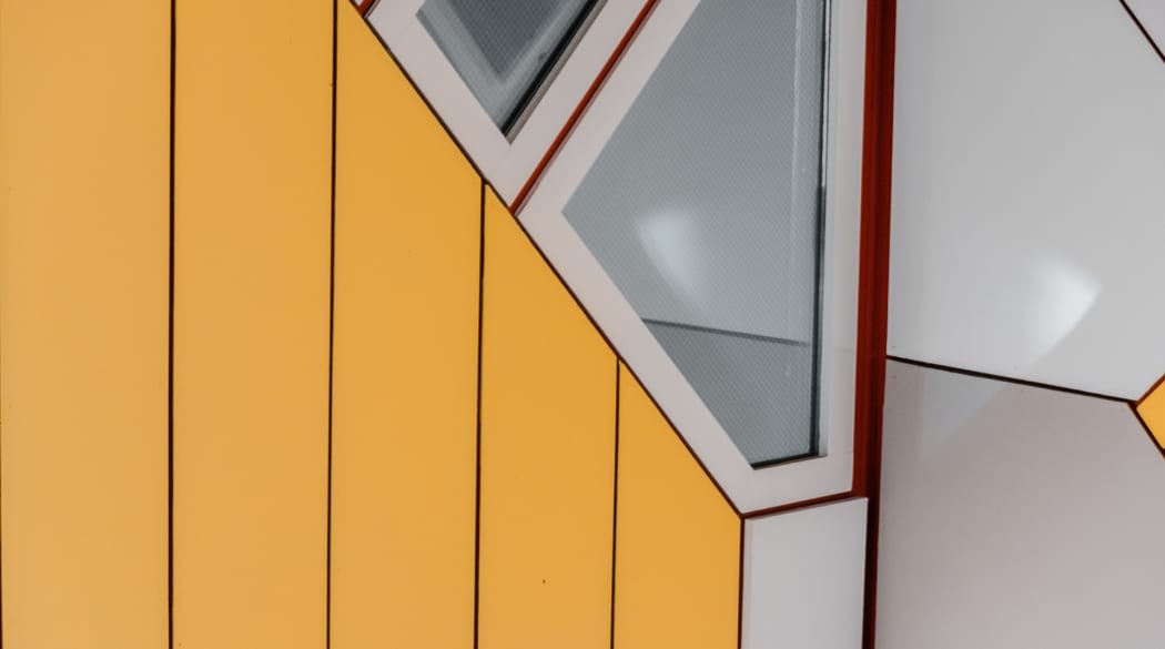 Detailaufnahme der gelb-grauen Fassade der Kubushäuser in Rotterdam
