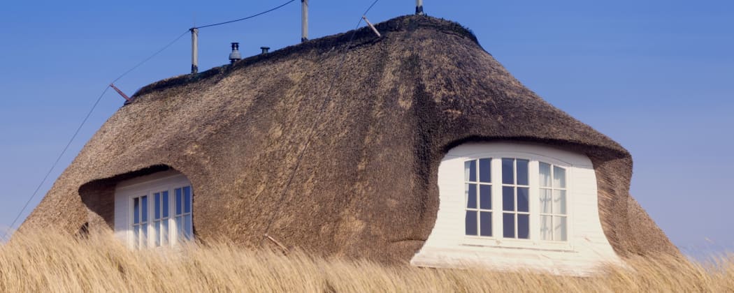 Traditionelle Dächer: ein Haus mit Reetdach (H)