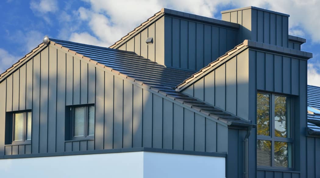 Stehfalz-Metall-Fassadenverblendung des Dachgeschosses.
